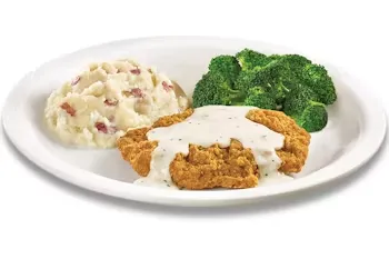 Denny’s 55+ Country Fried Steak with creamy gravy, served with mashed potatoes and vegetables.