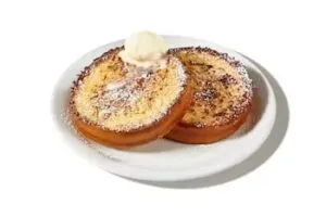 Denny’s side of French toast served golden brown with syrup.