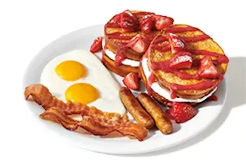 Denny’s Berry Stuffed French Toast Slam with thick toast filled with cream cheese, topped with strawberries, syrup, and paired with bacon and eggs.