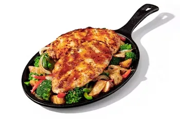 Denny’s Bourbon Chicken Skillet with grilled chicken in bourbon sauce served over vegetables.