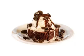 Denny’s Brownie Sundae topped with ice cream, Oreo cookie crumbles, and chocolate drizzle.