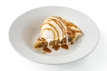 Denny’s Cookie Dough Lover’s Pie topped with chocolate drizzle and whipped cream.