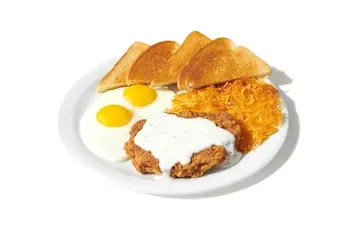 Denny’s Country Fried Steak & Eggs with crispy steak, creamy gravy, eggs, hash browns, and toast.