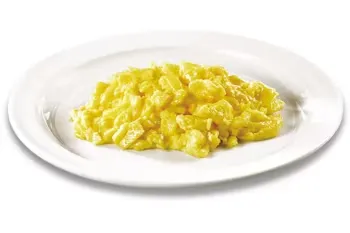 Denny’s scrambled eggs served in a portion on a white plate.