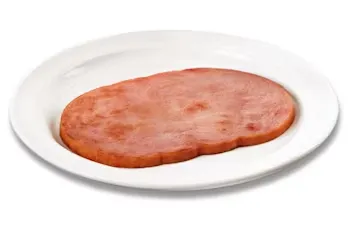 Denny’s grilled ham slice with fried egg on a white plate.