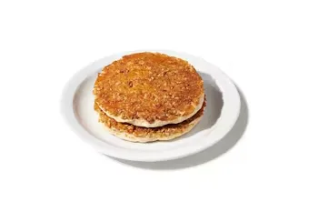 Denny’s hearty 9-grain pancake stack with multigrain texture served on a white plate.