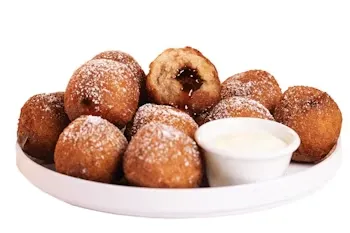 Denny’s Maple Stuffed Donut Churros dusted with sugar, served warm with dipping sauce on a round plate.