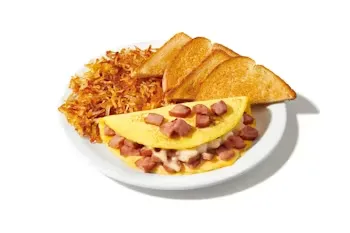 Denny’s Moons Over My Hammy Omelette filled with ham, scrambled eggs, melted cheese, served with crispy hash browns and toast.
