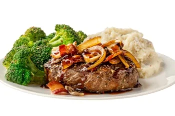 Denny’s Bourbon Bacon Sirloin Dinner with grilled sirloin steak topped with crispy onions and bacon, served with broccoli and mashed potatoes.