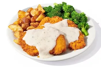 Denny’s Plate Lickin’ Chicken Fried Chicken with creamy gravy, mashed potatoes, and broccoli.