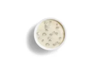 Denny’s creamy sausage gravy served in a small white bowl.