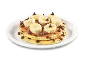 Denny’s stack of choconana pancakes with chocolate chips and banana slices on top.