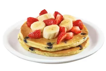Denny’s stack of strawberry pancakes topped with fresh strawberries and banana slices.