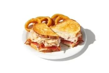 Denny’s Super Bird sandwich with sliced turkey, Swiss cheese, bacon, and tomato on sourdough.